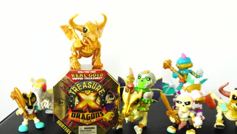 Die-Kamera-Zoomt-Langsam-In-Die-Goldene-Spielzeugkiste-„Schatz-X-Drachen“,-Umgeben-Von-Minifiguren