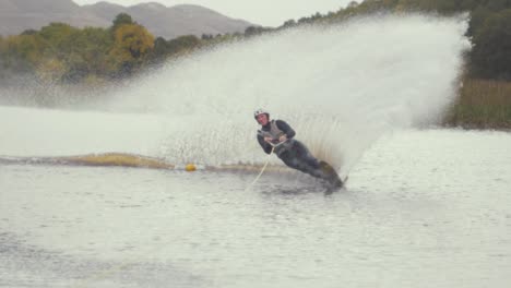 Man-Slalom-ski-cuts-around-buoy-water-ski-SLOW-MOTION