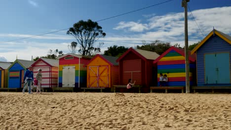 Tourists-walking-and-taking-photo-at-Brighton-Bathing-Boxes,-Melbourne,-Australia