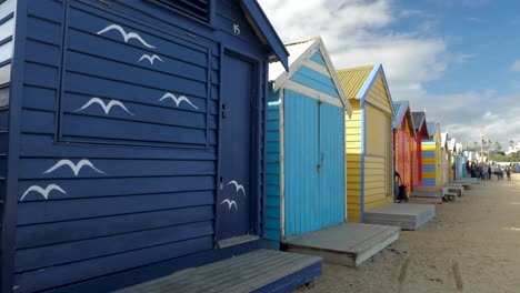 Tourists-walking-and-taking-photo-at-Brighton-Bathing-Boxes,-Melbourne,-Australia