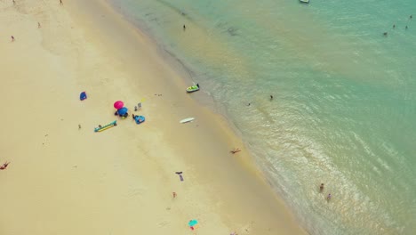 Flying-along-Karon-Beach-and-the-tourist-area-on-the-island-of-Phuket-in-Thailand,-the-Indian-Ocean-and-the-tourist-area-in-the-frame