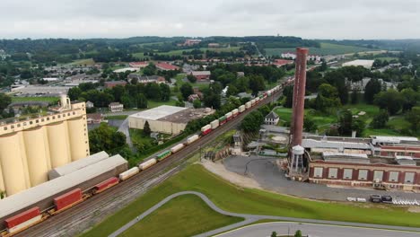 Aerial-drone-view-of-Hershey-Chocolate-Company-and-train-passing-by-storage-silos