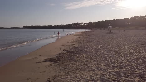 Left-pan,-people-with-kids-on-holiday-on-the-beach-of-Gatseau-at-sunset,-île-d'Oléron