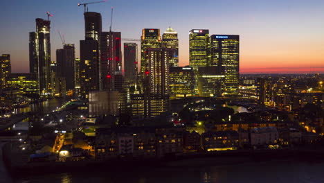 Aerial-view-of-the-financial-heart-of-London,-at-twilight-as-the-sun,-has-set-and-the-lights-of-the-skyscrapers-start-to-shine