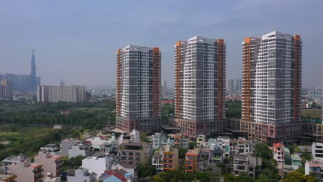 Aerial-tracking-shot-to-the-right-along-a-row-of-identical-modern-residential-buildings-on-a-sunny-day-with-blue-sky