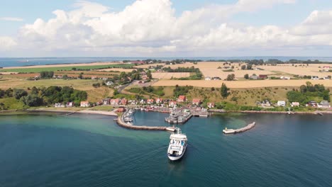 Aerial-view-of-the-ferry-Uraniborg-from-Ventrafiken-arriving-to-the-harbor-of-the-village-Bäckviken-on-the-island-of-Ven-in-southern-Sweden-during-a-warm-summer-day