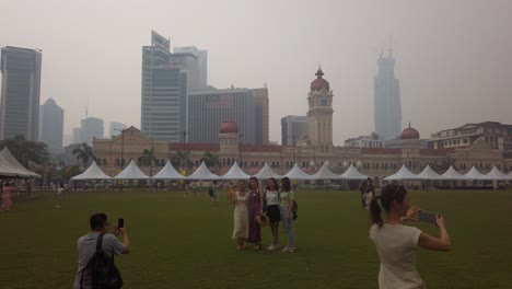 Turistas-Tomando-Fotografías-En-El-Dataran-Merdeka-En-Medio-De-Una-Espesa-Neblina-Causada-Por-Los-Incendios-Forestales-De-Indonesia