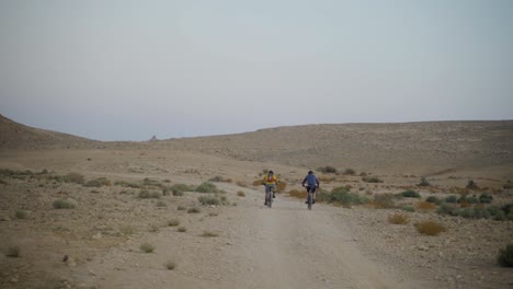 Two-cyclers-with-mountain-bikes-ride-off-road-in-the-desert-landscape