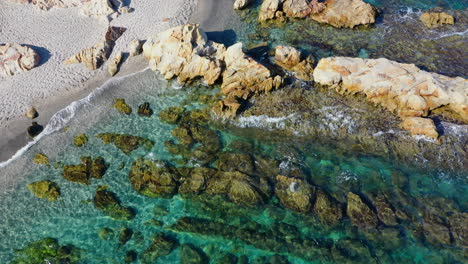 Statischer-Blick-Auf-Kristallklares-Mittelmeerwasser,-Das-Auf-Den-Strand-Mit-Felsformationen-Trifft,-Wunderschöner-Tropischer-Sommerurlaubstraum