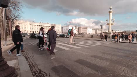 People-walking-over-crosswalk-while-cars-are-waiting-in-Paris,-France