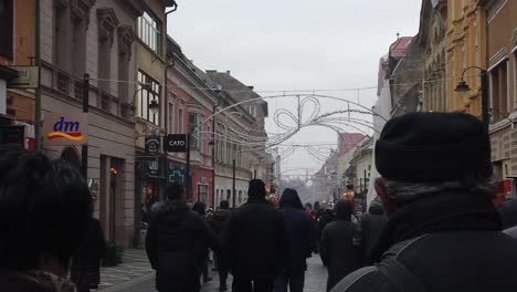 Paisaje-Urbano-En-Diciembre-En-Las-Calles-De-Brasov-Con-Luces-Navideñas-Y-Tiendas-En-Una-Zona-Turística-Y-Poblada