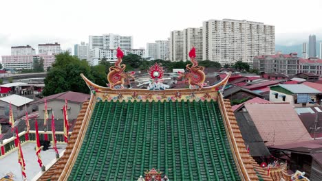 Dachdetails-Mit-Doppeldrachen-Und-Flammenkugel-Auf-Dem-Schwimmenden-Buddhistischen-Tempel-Kuan-Yin-Im-Clan-Anlegesteg-Der-Stadt,-Luftaufnahme-Mit-Dolly-Out