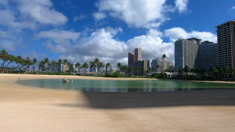 Beautiful-footage-of-a-quiet-sandy-bay-surrounded-by-hotels-on-a-sunny-day-in-Hawaii