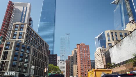 Dense-traffic-in-the-streets-of-Manhattan,-tilt-up-to-modern-skyscrapers-above-the-streets