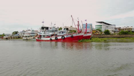 Barcos-De-Pesca-Amarrados-En-El-Barro-En-La-Orilla-De-Un-Río-Durante-La-Marea-Baja-En-Samut-Sakhon,-Tailandia-Y-Esperando-Ser-Desplegados-Nuevamente