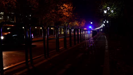 Stadtstraße-Mit-Autos-In-Der-Nacht,-Abstraktes-Muster-Mit-Schatten-Und-Blitzlichtern-Von-Krankenwagen,-Die-Sich-In-Der-Nähe-Von-Geländereisen-Auf-Dem-Bürgersteig-Bewegen