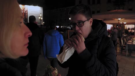 Mutter-Und-Sohn-Essen-Italienische-Sandwiches-Auf-Dem-Belebten-Straßenmarkt-In-Venedig,-Italien