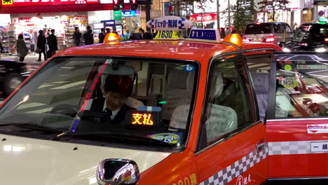 Closeup-view-of-Japanese-taxi-dropping-off-passengers-in-Tokyo,-Japan-at-night