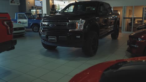 Black-Ford-F150-Pickup-Truck-Being-Revealed-in-a-Dealership-Showroom