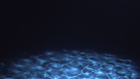 Underwater-blue-and-dark-sea-floor-with-caustics-at-bottom-of-ocean