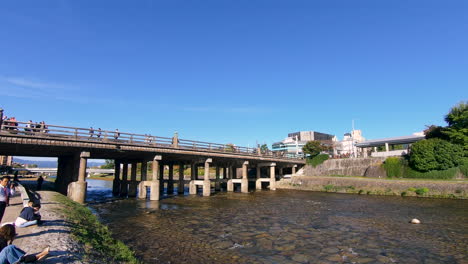 Una-Hermosa-Foto-Estática-De-Japoneses-Y-Turistas-Caminando-En-La-Parte-Superior-Del-Puente-Shijo-En-Kyoto,-Japón-Durante-La-Tarde-En-Otoño