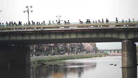 Menschen,-Die-Tagsüber-Auf-Der-Brücke-über-Den-Kamogawa-Fluss-In-Kyoto,-Japan,-Spazieren
