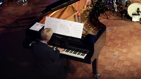 Back-shot-from-above,-Pianist-plays-grand-piano-with-elegance-at-concert