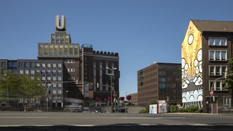 Time-lapse-of-traffic-passing-Dortmunder-U-building-against-bright-blue-sky