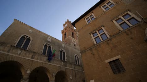 Große-Dolly-Aufnahme-Von-Gebäuden-Auf-Der-Piazza-Pio-Secondo,-Pienza,-Toskana-An-Einem-Sonnigen-Tag