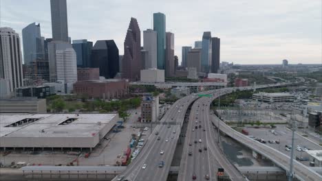 Luftaufnahme-Des-Verkehrs-Auf-Der-Autobahn-In-Der-Nähe-Der-Innenstadt-Von-Houston-An-Einem-Bewölkten-Tag-Während-Des-Sonnenuntergangs