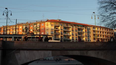 Still-wide-shot-of-Milan-Naviglio-Grande-Viale-Gorizia-bridge-with-people-and-tramway-during-the-evening