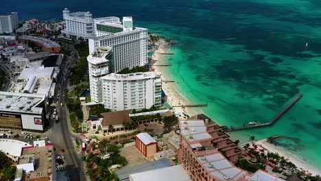 Panning-aerial-drone-footage-of-several-different-hotels-and-the-Caribbean-Sea-in-Northern-Cancun,-Mexico