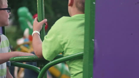 Kids-looking-sick-while-spinning-on-carnival-ride,-Close-Up,-Slow-Motion