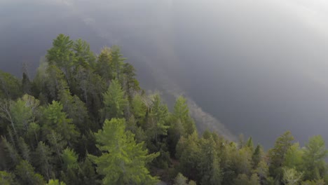 Spectacular-aerial-over-forestry-Big-Greenwood-Pond-reveal-mirror-reflective-water