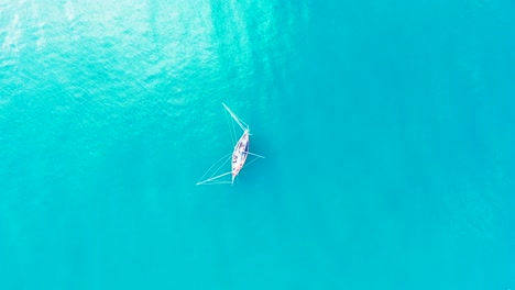 Fishing-boat-with-nets-hanging-over-calm-turquoise-water-of-lagoon-near-shoreline-of-tropical-island-in-Vietnam,-copy-space