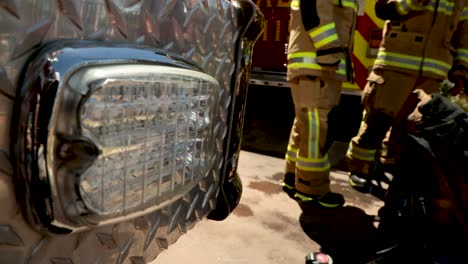 Warnlichter-Blinken-An-Einem-Feuerwehrauto,-Das-Auf-Einen-Notfall-Reagiert,-Mit-Feuerwehrleuten-Im-Hintergrund