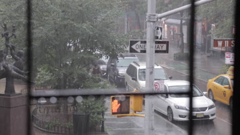 Rain-Falling-in-the-City,-Rack-Focus-From-Fire-Escape,-Taxicab,-Woman-With-Umbrella