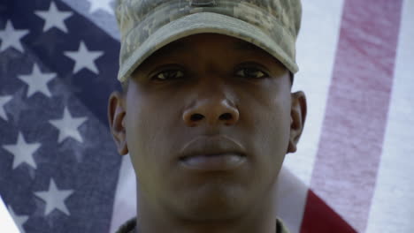 A-soldier-stands-in-front-of-a-waving-flag