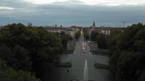Aerial-View-of-Munich-Germany-in-Twilight,-Bridge-Traffic-on-Isar-River-and-City-View-From-Maximilian-Park,-Pedestal-Drone-Shot