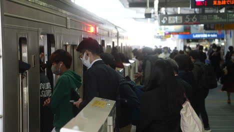 Passagiere-Mit-Gesichtsmaske-Steigen-Während-Der-Hauptverkehrszeit-In-Tokio,-Japan,-In-Die-U-Bahn