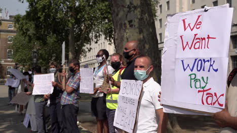 Undocumented-migrant-protestors-hold-placards-with-messages-demanding-their-human-rights,-to-be-made-legal,-to-be-given-the-right-to-work-and-ask-Prime-Minister-Boris-Johnson-to-keep-his-promise