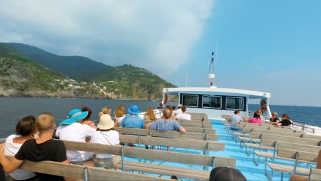 Blick-Auf-Manarola-Vom-Segelboot-Aus,-Das-Im-Meerwasser-Voller-Touristen-Schwimmt