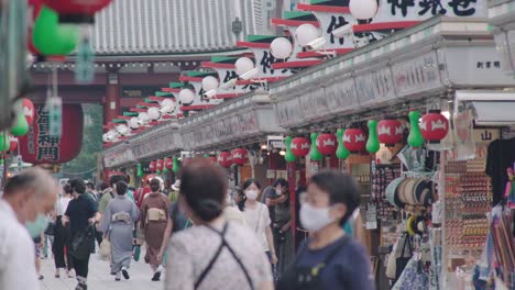 Reihen-Von-Geschäften-Und-Menschenmassen-Mit-Schutzmasken-In-Der-Nakamise-Einkaufsstraße-In-Asakusa,-Tokio,-Japan-Während-Der-Covid-19-Pandemie-–-Nahaufnahme