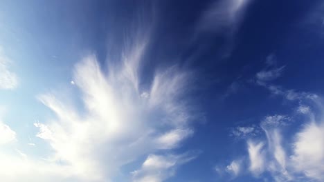 Dramatic-clouds-moving-slowly-against-clear-blue-sky-in-background