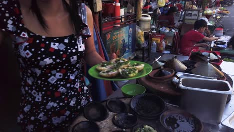 Vietnam,-Ho-chi-Minh-City,-a-woman-is-cooking-Vietnamese-crepes-in-a-street-food-stand-part-three