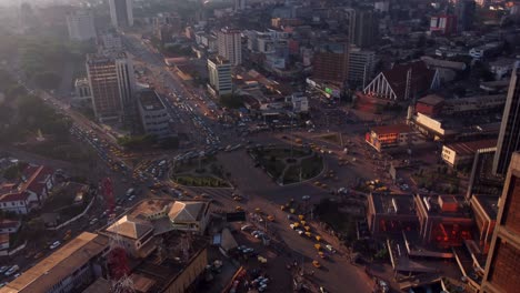Cinematic-aerial-of-downtown-Yaounde,-traffic-at-Poste-Centrale-roundabout