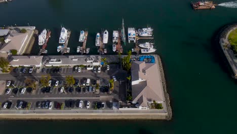 Aerial-pan-over-modern-harbor-and-parking-lot-on-sunny-day