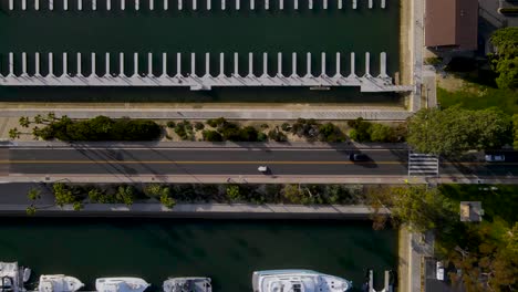 Birdseye-view-of-empty-and-full-docks,-cars-and-trees-casting-shadow