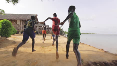 Fanático-Del-Fútbol,-Niños-Negros-Africanos-Corriendo-En-Las-Orillas-Del-Lago-Senegal