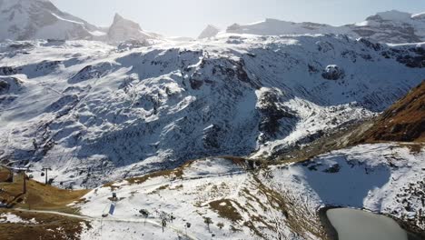 the-beautiful-Schwarzsee-in-the-snow-capped-swiss-mountains,-drone